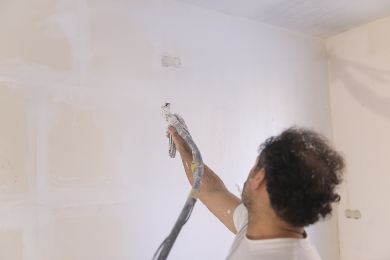 Szpachlowanie natryskowe ściany przez specjalistę